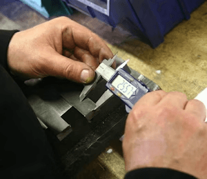 Operator checking a moulded part with a digital caliper