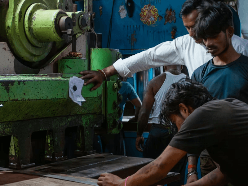 Workers operating heavy machinery on the production floor